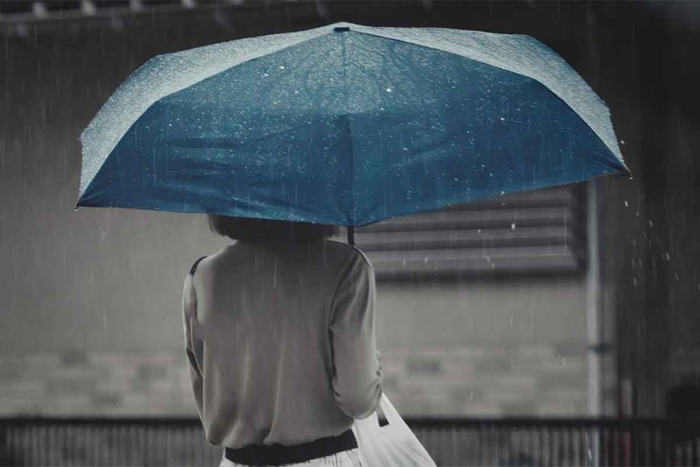雨の中傘をさす女性