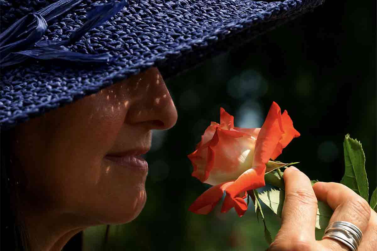 花の匂いをかぐ女性